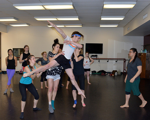 Female dancers practicing lifting a male dancer. 